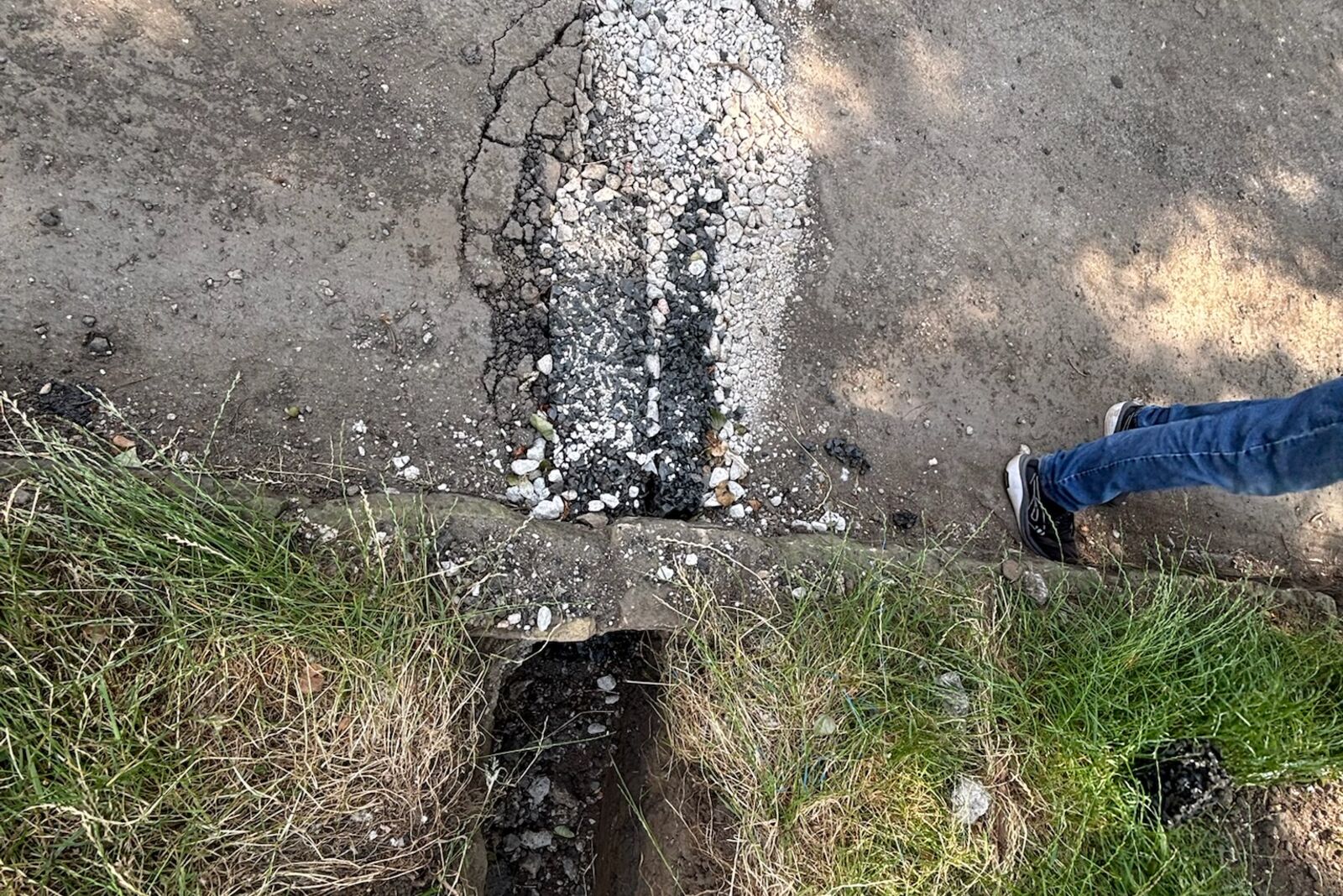 Grip Strip in its gravel-filled trench running across the path towards an outlet through the stone wall