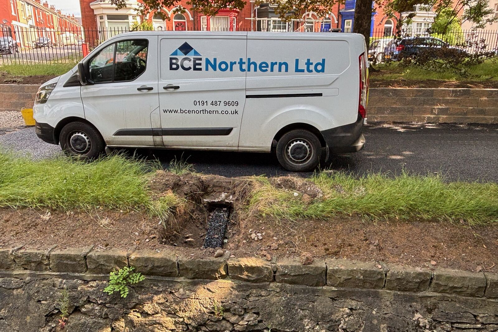 Grip Strip trench crossing the verge to an outlet through the heritage stone wall at Burn Valley Gardens, with the contractor's van behind