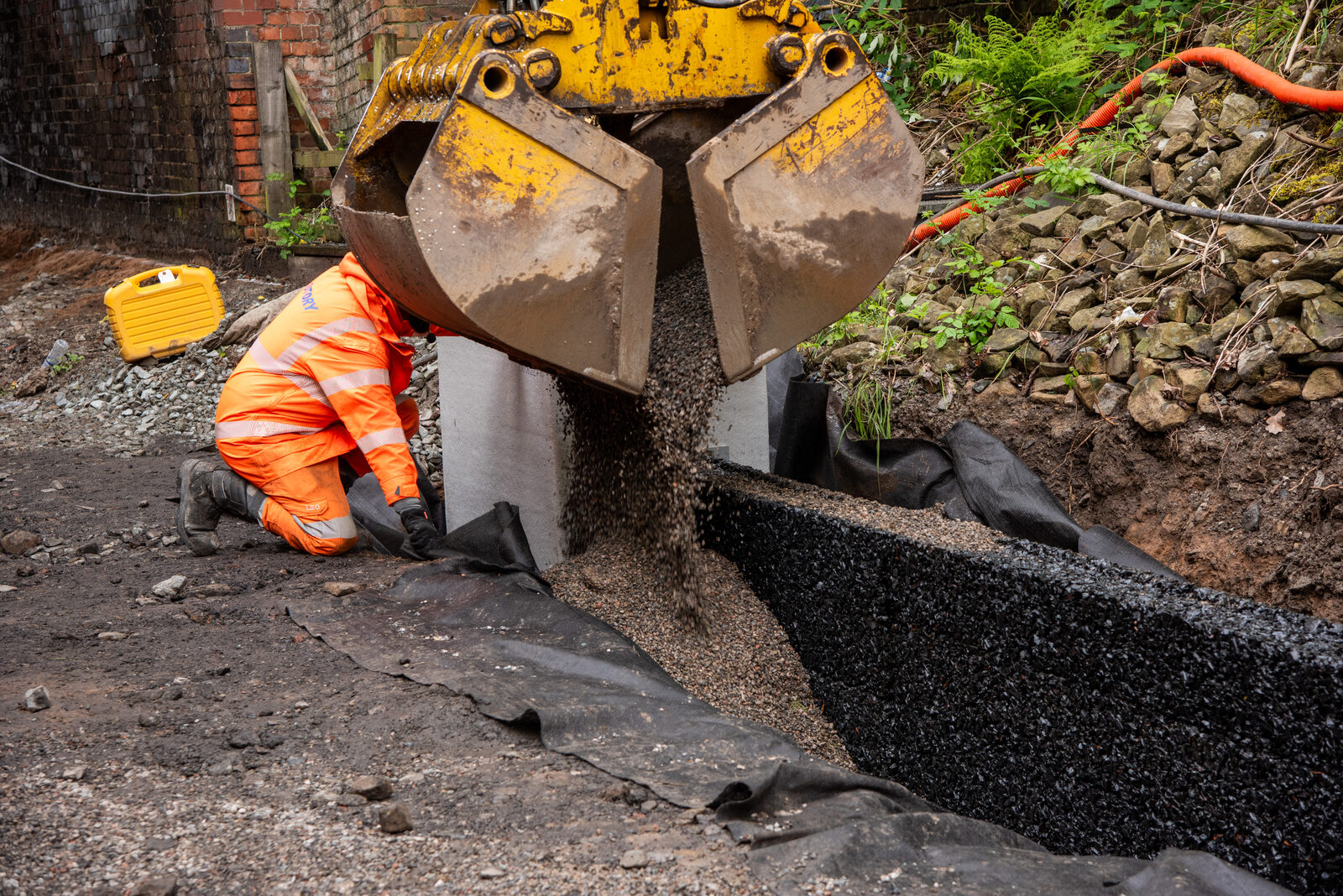 Placing aggregate around the installed drainage modules